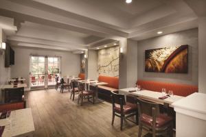 a restaurant with tables and chairs and a painting on the wall at Embassy Suites by Hilton Temecula Valley Wine Country in Temecula