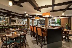 a restaurant with tables and chairs and a bar at Embassy Suites by Hilton Arcadia-Pasadena Area in Arcadia