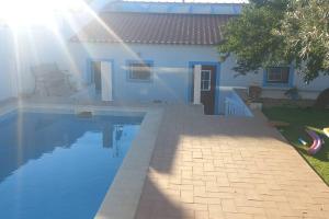 a house with a swimming pool in front of a house at Casa Margarida in Albernoa