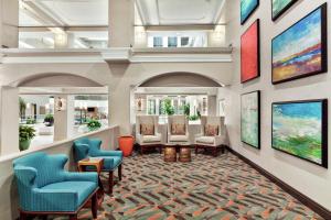 een lobby met stoelen en schilderijen aan de muur bij Embassy Suites by Hilton Santa Ana Orange County Airport in Santa Ana