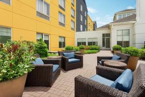 a patio with wicker chairs and tables in front of a building at Hilton Garden Inn Allentown Bethlehem Airport in Allentown