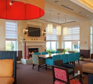 a dining room with a table and chairs and a fireplace at Hilton Garden Inn Allentown Bethlehem Airport in Allentown