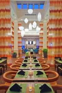 Hilton Garden Inn Allentown Bethlehem Airport في الينتاون: غرفة طعام كبيرة مع طاولة وكراسي طويلة