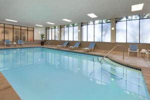 a large swimming pool with chairs in a building at Embassy Suites San Luis Obispo in San Luis Obispo