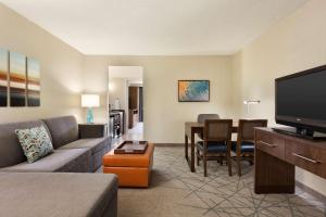 a living room with a couch and a flat screen tv at Embassy Suites San Luis Obispo in San Luis Obispo