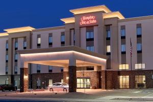 a hotel with a car parked in front of it at Hampton Inn & Suites Albuquerque Airport in Albuquerque