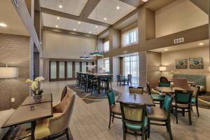 a restaurant with tables and chairs in a room at Hampton Inn & Suites Albuquerque Airport in Albuquerque