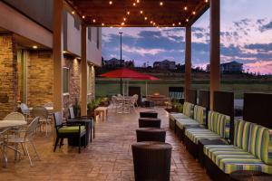 a patio with couches and tables and chairs at Home2 Suites by Hilton Grovetown Augusta Area in Augusta