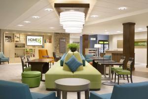 vestíbulo con sofá, mesas y sillas en Home2 Suites by Hilton Grovetown Augusta Area en Augusta