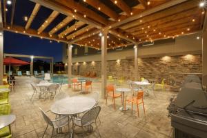 een patio met tafels en stoelen en een zwembad bij Home2 Suites by Hilton Grovetown Augusta Area in Augusta