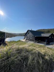 a house on a hill next to a body of water at Panoramahytte in Norheimsund