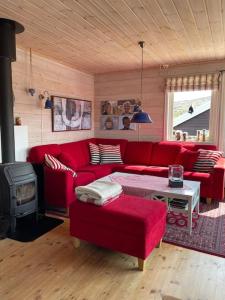 sala de estar con sofá rojo y fogones en Panoramahytte en Norheimsund