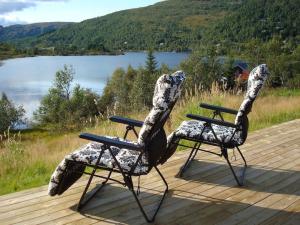 2 sillas en una terraza con vistas al lago en Panoramahytte en Norheimsund