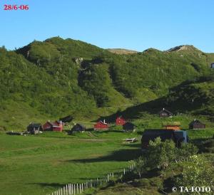 a group of houses in a field with a hill at Panoramahytte in Norheimsund