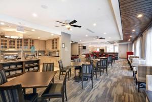um restaurante com mesas e cadeiras e uma cozinha em Homewood Suites by Hilton Athens Downtown University Area em Athens