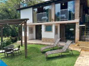 a house with chairs and a table in the yard at Pousada Estância Vip in Cunha