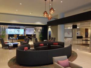 a lobby with a couch and tables and chairs at Hilton Albany in Albany