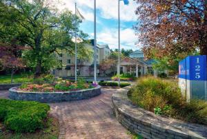 a brick walkway with flowers in front of a building at Hilton Garden Inn Saratoga Springs in Saratoga Springs