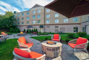 un patio con sillas y una mesa frente a un edificio en Hilton Garden Inn Saratoga Springs, en Saratoga Springs