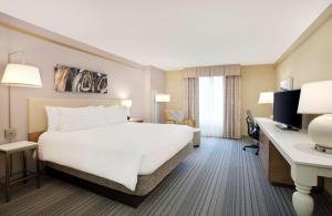 Habitación de hotel con cama y escritorio en Hilton Garden Inn Saratoga Springs, en Saratoga Springs