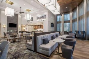 vestíbulo con sofá, mesas y sillas en Homewood Suites By Hilton Saratoga Springs en Saratoga Springs