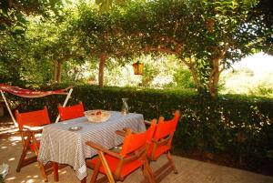 una mesa con sillas naranjas y una mesa con un plato de comida en Aiolis Rooms, en Kamariotissa