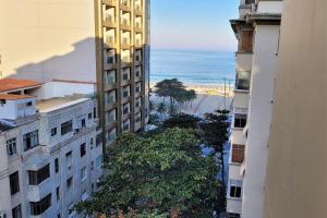 een uitzicht op het strand tussen twee gebouwen bij Apartamento 1 quadra da praia in Rio de Janeiro