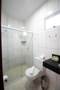 ein Badezimmer mit Toilette und Glasdusche in der Unterkunft Pousada Vovó Zilda Maragogi in Maragogi