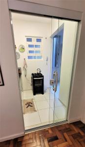 a glass door leading into a bathroom with a stove at Apartamento 1 quadra da praia in Rio de Janeiro