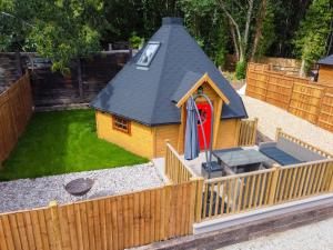 a small house with a playground in a backyard at Woods Meadow Glamping in West Malling