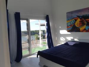 een slaapkamer met een bed en een groot raam bij Cabana de la Dunare in Basarabi