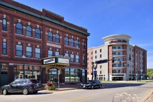 una calle de la ciudad con coches estacionados frente a los edificios en Hampton Inn Cedar Falls Downtown, Ia en Cedar Falls