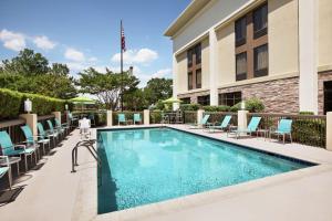 a swimming pool at a hotel with chairs and a building at Hampton Inn Richmond/Ashland in Ashland