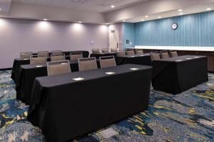 锡达福尔斯Hampton Inn Cedar Falls Downtown, Ia的一间会议室,里面配有椅子和墙上的时钟 更多37张照片
