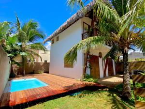 a villa with a swimming pool in front of a house at Kanaloa Village 02 in Icaraí