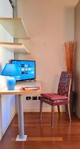 Zimmer mit einem Schreibtisch mit Stuhl und einem TV in der Unterkunft CASA DI GIULIA con soggiorno e cucina, camera matrimoniale con tetto a vista e grande parco circostante in Serravalle dʼAsti