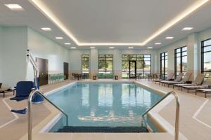 a large swimming pool with chairs and tables in a building at Tru by Hilton Albany Crossgates Mall in Albany