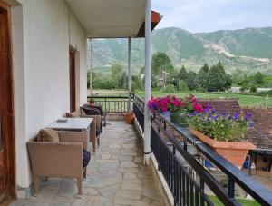 een patio met tafels, stoelen en bloemen op een balkon bij ΚΤΗΜΑ ΜΠΟΡΑΒΟΥ in Kastoria