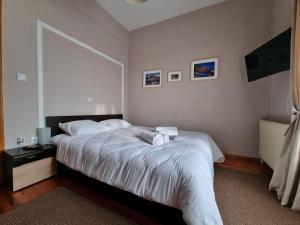 a bedroom with a bed with white sheets and a window at ΚΤΗΜΑ ΜΠΟΡΑΒΟΥ in Kastoria