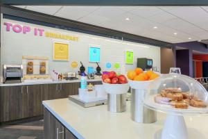 a counter with bowls of fruit on it in a cafeteria at Tru by Hilton Amarillo West in Amarillo