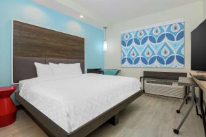 Dormitorio con cama, escritorio y pintura en Tru by Hilton Amarillo West, en Amarillo