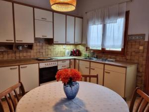 een keuken met een tafel met daarop een vaas met bloemen bij ΚΤΗΜΑ ΜΠΟΡΑΒΟΥ in Kastoria