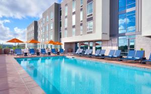 a swimming pool at a hotel with chairs and umbrellas at Hampton Inn & Suites Anaheim Resort Convention Center in Anaheim
