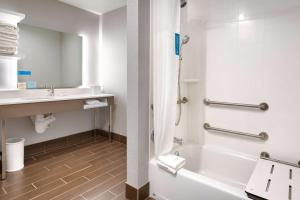 a bathroom with a tub and a sink at Hampton Inn & Suites Anaheim Resort Convention Center in Anaheim