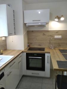 una cucina con armadi bianchi e piano cottura di Appartement T2, 4 personnes, disponible jusqu au Samedi 2 sept 2023 a Le Cannet-des-Maures
