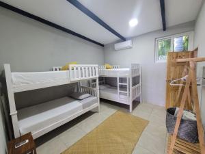 a room with two bunk beds and a ladder at LOOKING2GOOD in El Zonte