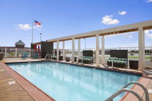 a swimming pool with chairs and an american flag at Home2 Suites by Hilton - Oxford in Oxford