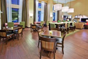 un comedor con mesas, sillas y ventanas en Hampton Inn & Suites Oxford-Anniston, en Oxford