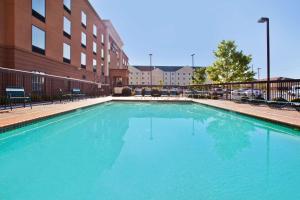 une grande piscine bleue en face d'un bâtiment dans l'établissement Hampton Inn & Suites Oxford-Anniston, à Oxford