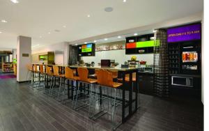 um restaurante com um bar com cadeiras laranja em Home2 Suites by Hilton - Oxford em Oxford